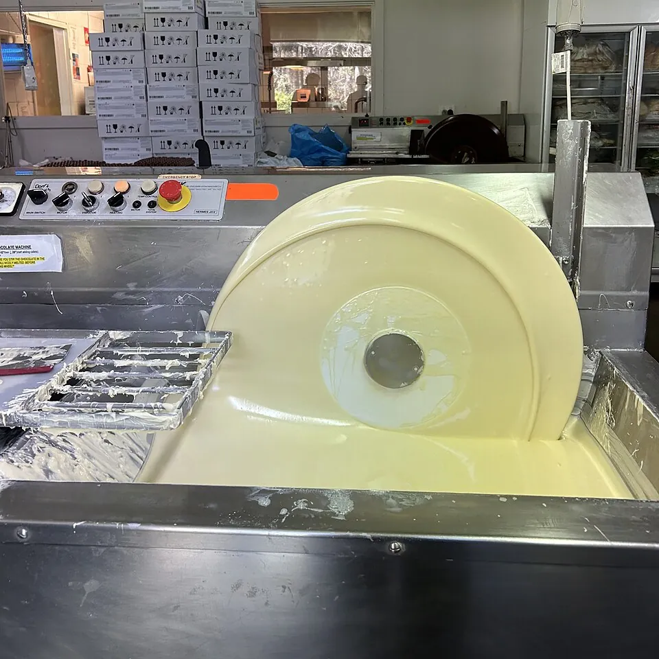 テンパリングの機械の中のホワイトチョコ